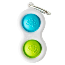Load image into Gallery viewer, The Simpl Dimpl by Fat Brain Toy Co is a white keychain with blue and green brain-design buttons, ideal for on-the-go tactile fun.