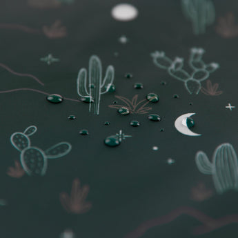 Close-up of water droplets on a green Bumkins Reusable Snack Bag, Small 2 Pack: Desert Night.