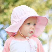 Load image into Gallery viewer, A toddler wears a Bumkins Sun Hat, Pink, and shirt outdoors against a blurred green background.