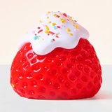 Showcase Squeezesquad - Strawberry: a red squishy fidget toy with white frosting and sprinkles—fun stress relief for all!.