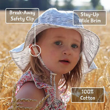 Load image into Gallery viewer, Young child in a wheat field wearing the Bumkins Sun Hat, Pink—adjustable with break-away safety clip and UPF 50+ cotton.