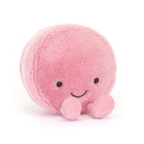 Jellycat Amuseables Mia Macaron plush, pink with a smile and pink feet, sits on a white background.