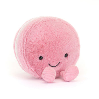 Jellycat Amuseables Mia Macaron plush, pink with a smile and pink feet, sits on a white background.