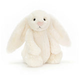 A Jellycat Bashful Bunny Cream plush with floppy ears and a pink nose sits upright on a white background.