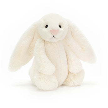 A Jellycat Bashful Bunny Cream plush with floppy ears and a pink nose sits upright on a white background.