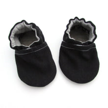 Load image into Gallery viewer, Cabooties Denim Black: Small black baby shoes with white stitching, ruffled edges, and flexible rubber soles on a white background.