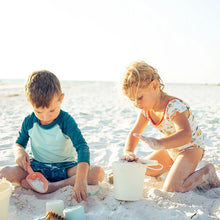 Load image into Gallery viewer, Two kids focus intently on their sandcastle using the Emerson and Friends Beach Bucket Toy Play Set under the sunny sky.