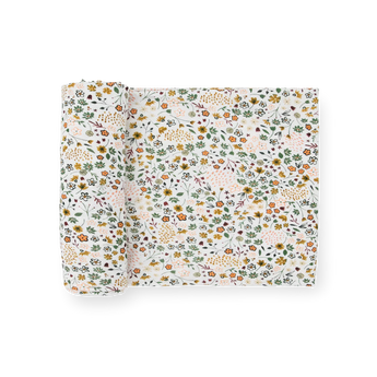 Little Unicorn Stretch Knit Swaddle Blanket in Pressed Petals: white with green, orange, and yellow floral print.