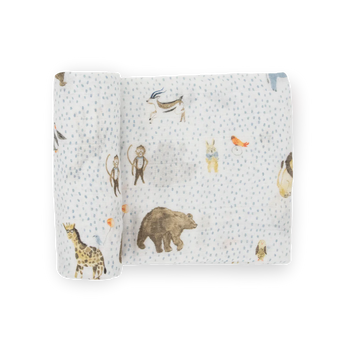 Little Unicorn Cotton Swaddle, Party Animals: white muslin with blue dots & animal prints; breathable blanket, partially rolled up.