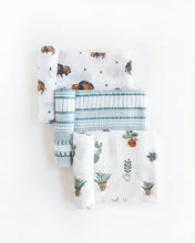 Load image into Gallery viewer, Set of three folded muslin swaddles by Little Unicorn with bison, geometric lines, and potted plants on white.