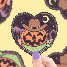 Load image into Gallery viewer, Turtle Soups Cowboy Pumpkin vinyl sticker features a jack-o-lantern in a heart-shaped desert night scene with cowboy hat and bandana.