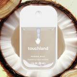 Hydrating Hand Sanitizer: clear sanitizer bottle with white cap & text "touchland Power Mist Hydrating hand sanitizer" on a coconut half.