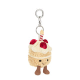 Jellycat, Bag Charm Amuseables Birthday Cake with a face, strawberries, and a candle hanging from a keyring.