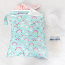 Load image into Gallery viewer, Bumkins Wet/Dry Bag: Rainbows holds a pink diaper and white cloth on a marble surface next to a breast pump.