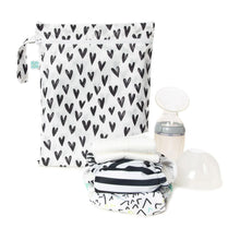 Load image into Gallery viewer, A breast pump and a stack of cloth diapers sit in front of Bumkins Wet/Dry Bag: Hearts on a white background.