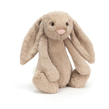 The Jellycat Bashful Beige Bunny Huge sits upright, featuring floppy ears, a pink nose, and a fluffy white tail.
