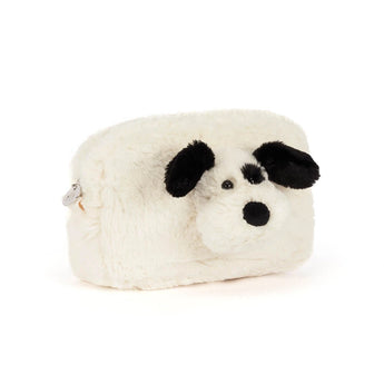 A cream-colored, fuzzy Jellycat Pouch Rufferty Puppy shaped like a playful puppy with black ears, a black nose, and a black eye patch.