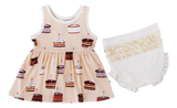 The Blake Birdie Peplum Set by Birdie Bean features a sleeveless cake print dress and ivory ruffled bloomers for a charming look.