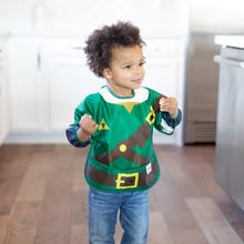Load image into Gallery viewer, A young curly-haired child stands in a kitchen while wearing a Bumkins Sleeved Bib: Zelda™.