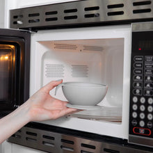 Load image into Gallery viewer, A person places a Bumkins Silicone First Feeding Set: Gray into an open microwave.