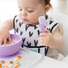 Load image into Gallery viewer, Close-up of a baby eating messily from a purple bowl while holding a Bumkins Silicone Chewtensils®: Purple Jelly.