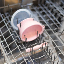 Load image into Gallery viewer, Bumkins Silicone First Feeding Set: Pink sits in the top rack of an open dishwasher.