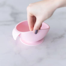 Load image into Gallery viewer, A hand holds a Bumkins Silicone First Feeding Set: Pink, demonstrating the suction cup bottom on a marble surface.