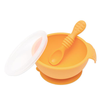 Bumkins Silicone First Feeding Set: Tangerine includes a bowl with suction bottom, a matching spoon, and a transparent lid.