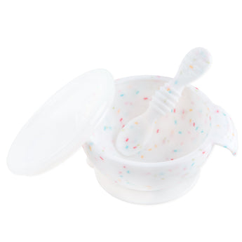 Bumkins Silicone First Feeding Set: Vanilla Sprinkle includes a white speckled bowl with secure suction base, matching spoon, and clear lid.