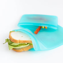 Load image into Gallery viewer, A sandwich with lettuce, and sliced bell peppers in Bumkins Silicone Flat Reusable Bag 2 Pack, Blue on a white background.