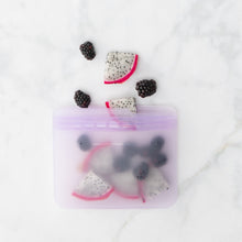 Load image into Gallery viewer, A Bumkins Silicone Flat Reusable Bag 2 Pack, Lavender holds dragonfruit slices and blackberries on a marble surface.
