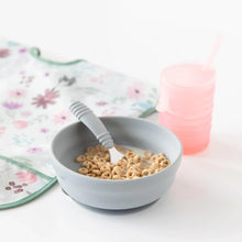 Load image into Gallery viewer, Bumkins Silicone Grip Bowl: Gray with cereal and milk, a gray spoon, a pink sippy cup, and floral bib on a white background.