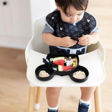 Load image into Gallery viewer, A toddler in a high chair wearing a black bib enjoys oatmeal, fruit, and cereal from a Bumkins Silicone Grip Dish: Mickey Mouse.