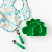 Load image into Gallery viewer, Bumkins Silicone Grip Dish, Special Edition: Dino lays next to a dinosaur patterned bib and green utensils on a white background.
