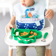Load image into Gallery viewer, A toddler enjoys a meal from a Bumkins Silicone Grip Dish, Special Edition: Dino with green utensils in a high chair, wearing a dinosaur bib.