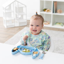 Load image into Gallery viewer, A smiling baby in a pastel bib enjoys fruit from a Bumkins Silicone Grip Dish: Stitch at a white table in a bright playroom.