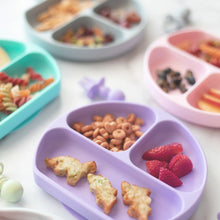 Load image into Gallery viewer, Bumkins Silicone Grip Dish: Lavender, holding cereal and fruit, sits among other food-filled dishes and utensils on a white background.
