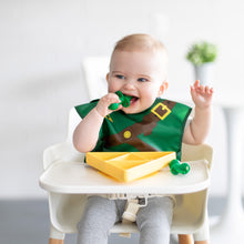 Load image into Gallery viewer, A baby in a high chair wearing a bib, smiling while eating from a Bumkins Silicone Grip Dish: Zelda™ Triforce using green baby utensils.