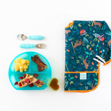 Scrambled eggs, bacon, and waffles in a Bumkins Silicone Grip Dish: Blue Jelly, with cutlery and bright bib nearby on a white background.