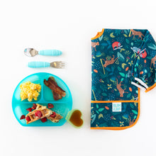 Load image into Gallery viewer, Scrambled eggs, bacon, and waffles in a Bumkins Silicone Grip Dish: Blue Jelly, with cutlery and bright bib nearby on a white background.