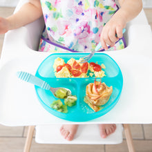 Load image into Gallery viewer, A child in a high chair enjoys eggs, tomatoes, kiwi, and pancakes from a Bumkins Silicone Grip Dish: Blue Jelly.