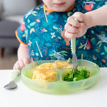 Load image into Gallery viewer, A child enjoys broccoli, pasta, and cornbread from a Bumkins Silicone Grip Dish: Green Jelly, in a vibrant bib.