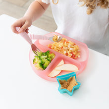 Load image into Gallery viewer, A child enjoys a meal from a Bumkins Silicone Grip Dish: Pink Jelly filled with pasta, broccoli, and apples, with peanut butter in a star bowl.
