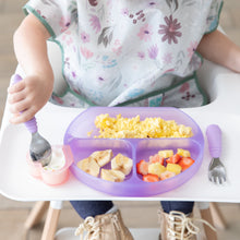 Load image into Gallery viewer, A child in a high chair enjoys scrambled eggs, bananas, and fruit salad from a Bumkins Silicone Grip Dish: Purple Jelly using a spoon.