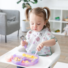 Load image into Gallery viewer, A toddler with pigtails sits in a high chair, enjoying scrambled eggs and fruit from a Bumkins Silicone Grip Dish: Purple Jelly.
