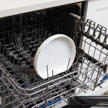 Load image into Gallery viewer, Bumkins Silicone Grip Plate: Vanilla Sprinkle sits in the top rack of an open dishwasher.
