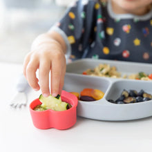 Load image into Gallery viewer, Close-up of a child joyfully dipping a cucumber in a red Bumkins Silicone Little Dipper 3-Pack: Tutti-Frutti attached to a plate of food.