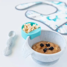 Load image into Gallery viewer, A blue Bumkins Silicone Little Dipper Round 3-Pack: Gumdrop with cereal attached to a bowl, with a spoon and bib nearby on a white background.