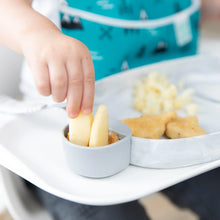 Load image into Gallery viewer, Close-up of a child dipping apple slices into peanut butter in a gray Bumkins Silicone Little Dipper Round 3-Pack: Taffy attached to a plate.