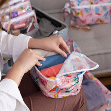 Load image into Gallery viewer, Someone packs colorful clothes into Bumkins Packing Cube 2 Pack: Boots while an open suitcase sits in the background.